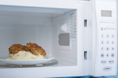 Gıda Isıtma için mavi bir ahşap yüzey üzerinde beyaz mikrodalga fırın