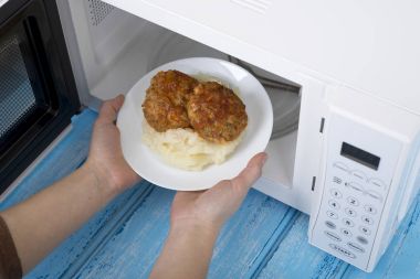 Gıda Isıtma için mavi bir ahşap yüzey üzerinde beyaz mikrodalga fırın