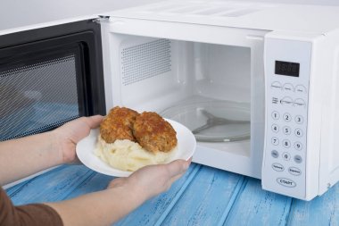 Gıda Isıtma için mavi bir ahşap yüzey üzerinde beyaz mikrodalga fırın