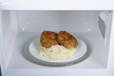 Gıda Isıtma için mavi bir ahşap yüzey üzerinde beyaz mikrodalga fırın