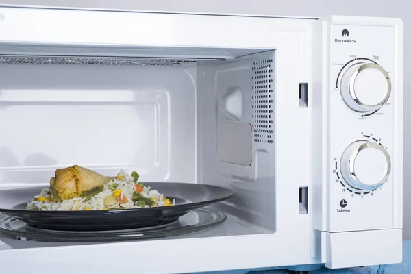 White microwave oven, on a blue wooden surface for heating food — Stock Photo, Image