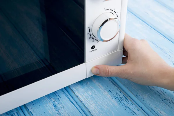 Gıda Isıtma için mavi bir ahşap yüzey üzerinde beyaz mikrodalga fırın