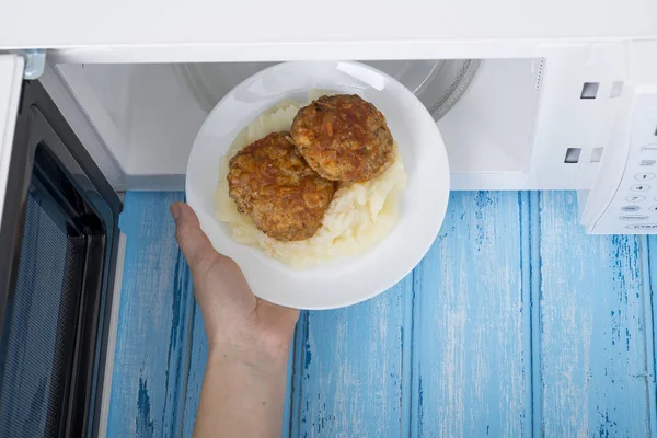 Forno de microondas branco, sobre uma superfície de madeira azul para aquecimento de alimentos — Fotografia de Stock