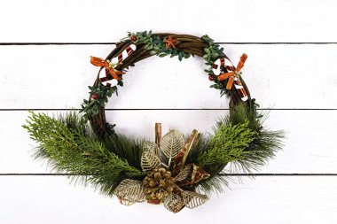 Beyaz ahşap arka planda dairesel bir çelenk. Yılbaşı kavramına sahip arka plan.