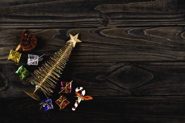 Yıldızlı küçük bir Noel ağacı ve siyah ahşap arka planda çeşitli renkli hediyeler. Noel konsepti.