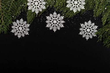 Noel kompozisyonu. Siyah arka planda kar ve damlaları olan Girlanda. Noel, kış, yeni yıl konsepti. Düz konum, üst görünüm, kopyalama alanı.