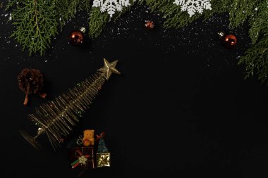Noel kompozisyonu. Siyah arka planda yıldızı olan altın metal ağacı. Noel, kış, yeni yıl konsepti. Düz konum, üst görünüm, kopyalama alanı.