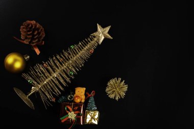 Noel kompozisyonu. Siyah arka planda yıldızı olan altın ağaç. Noel, kış, yeni yıl konsepti. Düz konum, üst görünüm, kopyalama alanı.