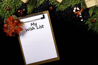 Noel kompozisyonu. İçinde Noel süsleri, siyah arka planda hediyeler ve boş not defterleri olan Girlanda. Noel, kış, yeni yıl konsepti. Düz konum, üst görünüm, kopyalama alanı.