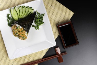 Siyah arka planda beyaz tabakta somon temaki suşisi. Japon mutfağı..