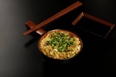 Zencefil ve soğanla hazırlanmış somon carpaccio. Siyah arka planda bir kasede servis edilmiş..