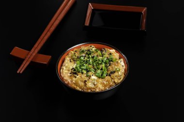 Zencefil ve soğanla hazırlanmış somon carpaccio. Siyah arka planda bir kasede servis edilmiş..