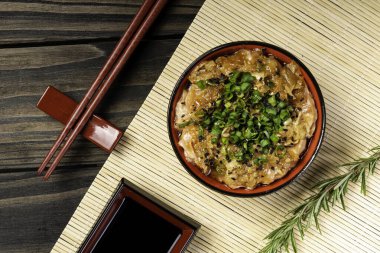 Zencefil ve soğanla hazırlanmış somon carpaccio. Siyah ahşap arka planda bir kasede servis edilmiş..