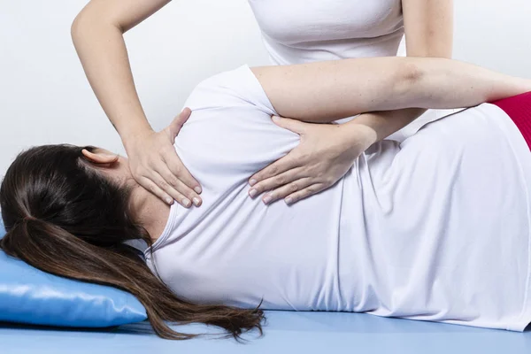 Woman having chiropractic back adjustment. Osteopathy, Alternative medicine, pain relief concept. Physiotherapy, sport injury rehabilitation.
