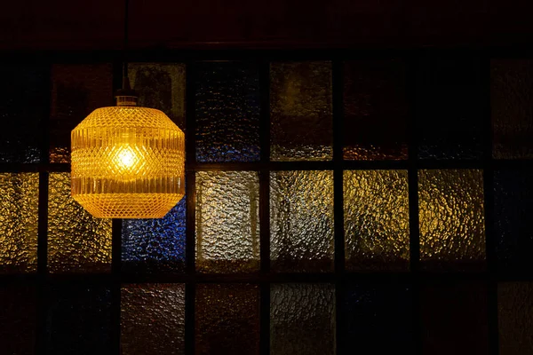 Lampa Żółtą Lampą Tło Oknem Kolorowych Okularów — Zdjęcie stockowe