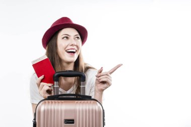 Güzel, mutlu bir kadın bavulunu, pasaportunu, haritasını ve biniş biletini tutuyor. Hava yolculuğu konsepti.