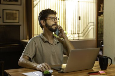 Karantina sırasında telefonda konuşan göz kamaştırıcı İspanyol model. Merkez ofis kavramı.