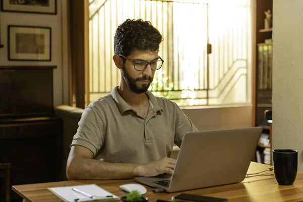 Beautiful Hispanic model typing on his personal computer. Home office concept.