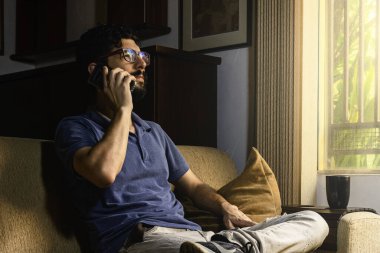 Evden çalışan bir adam. Karantina sırasında kanepede oturmak..