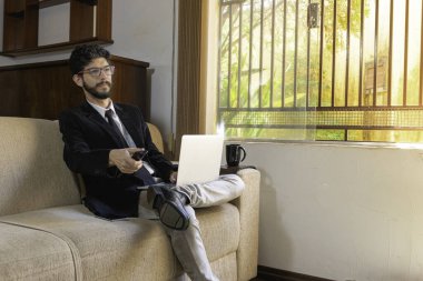 İş adamı evinde çalışıyor ve televizyondaki haberleri kontrol ediyor..