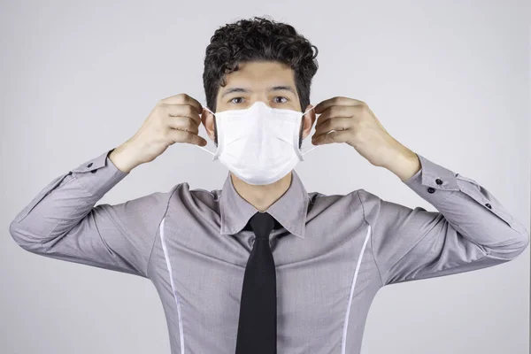 Hombre Latino Poniéndose Máscara Protectora Durante Pandemia Con Fondo Gris — Foto de Stock