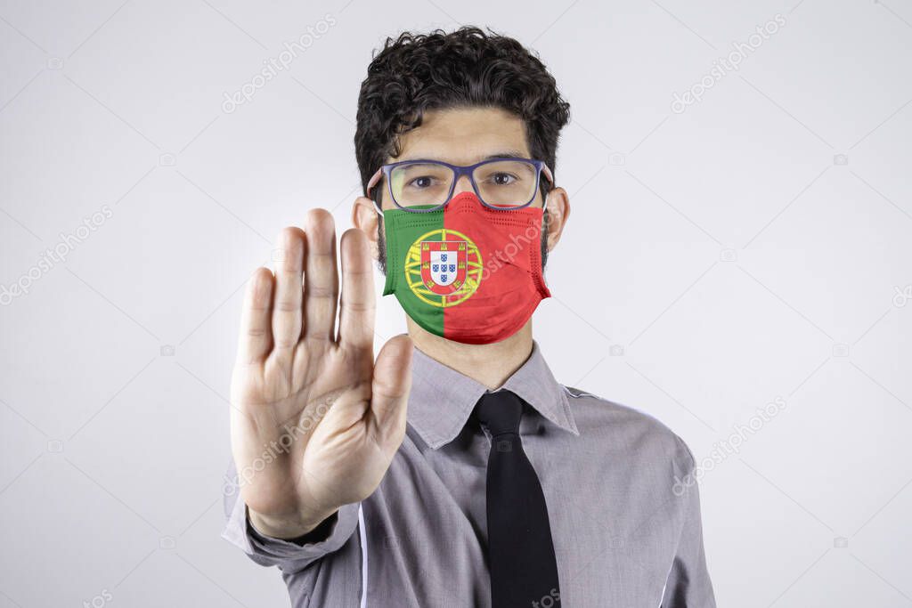 Man wearing mask with Portugal flag asking to keep a social distance. Covid-19, SARS-CoV-2. Concept of social distance.