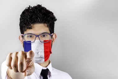 Man in mask with France flag pointing at you. Stay at home concept. clipart