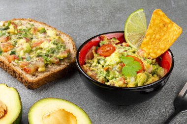 Gri taşlı arka planda tam ekmekli guacamole. Fast food.