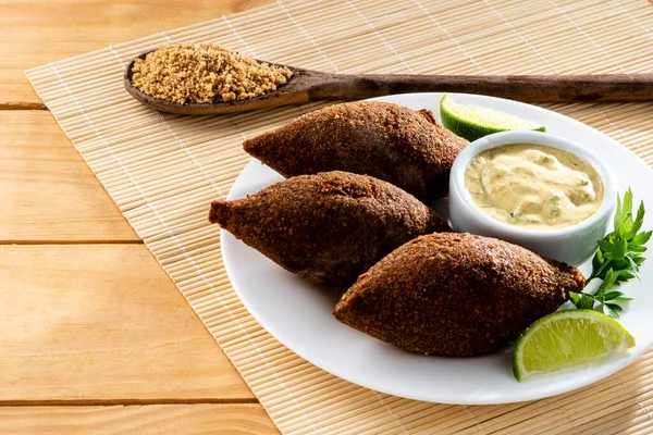 Arabic cuisine meat appetizer kibbeh close-up on a plate. Also popular party dish in Brazil, Kibe.