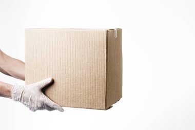 Koruyucu eldivenle teslimat için karton kutu tutan bir adam. Bakkal teslimatı konsepti.