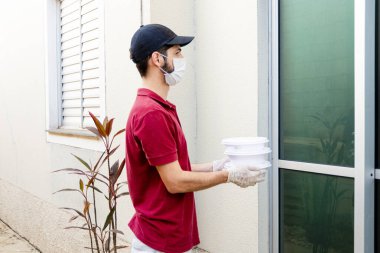 Elinde beslenme çantası olan ya da teslimatı bekleyen bir adam..