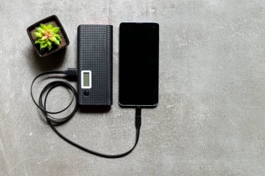 Çalışma masasında ekstra pil ve cep telefonu var..