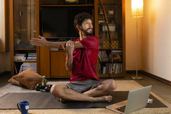 年轻的西班牙裔男子在网上课上做伸展运动 家庭锻炼概念 — 图库照片