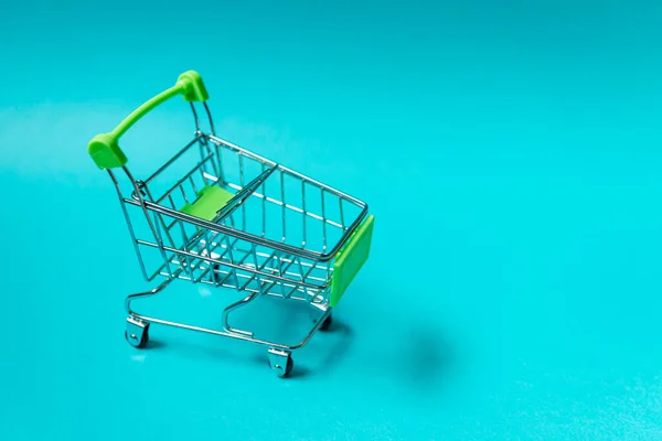 Shopping cart on blue background. E-commerce concept.