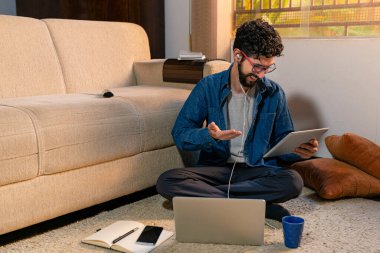 Latince ofisinde otururken bir video görüşmesi yapıyor..
