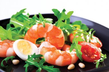Kral'ın salata karides ve rukola siyah bir tabak içinde