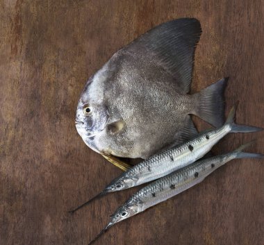 Siyah düz balık ve iki iğne-balık vintage eski ahşap arka plan üzerinde yakın çekim