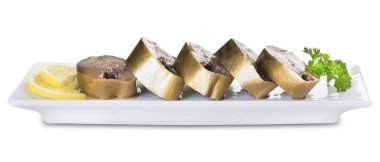 Uskumru ve beyaz bir arka plan üzerinde beyaz bir plaka üzerinde limon parçaları