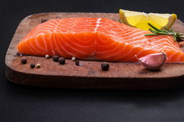 salmon and spices on a wooden cutting board