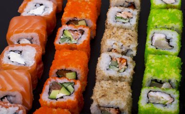 Japon suşisi siyah arka plan görünümünde yuvarlanıyor.