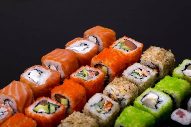 Japon suşisi siyah arka plan görünümünde yuvarlanıyor.
