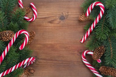 Çelenkler, koniler ve karamel ile süslenmiş Noel ağacı dalı