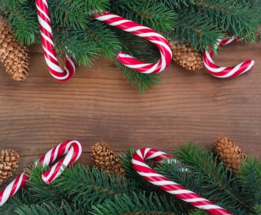 Çelenkler, koniler ve karamel ile süslenmiş Noel ağacı dalı