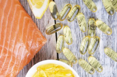 Bir avuç dolusu omega 3 somon fileto ve somon somonu ahşap bir masada.