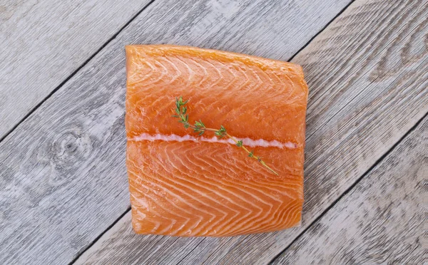 新鲜的鲑鱼片 带有百里香枝条 装在老式木板上 — 图库照片