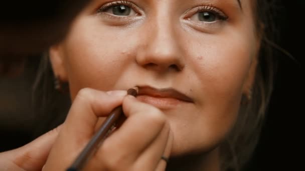 Maquillar artista haciendo profesional maquillaje de mujer joven — Vídeos de Stock