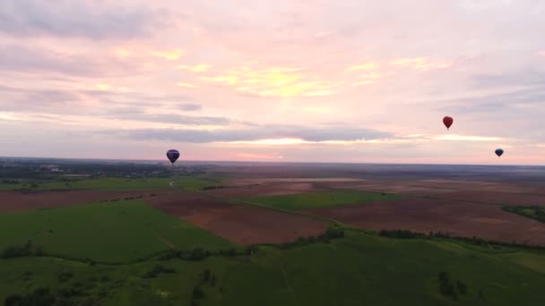 Hőlégballonok az égen át egy mezőt. Légifelvételek — Stock videók