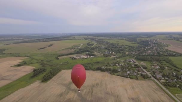 Heißluftballon am Himmel über einem Feld. — Stockvideo