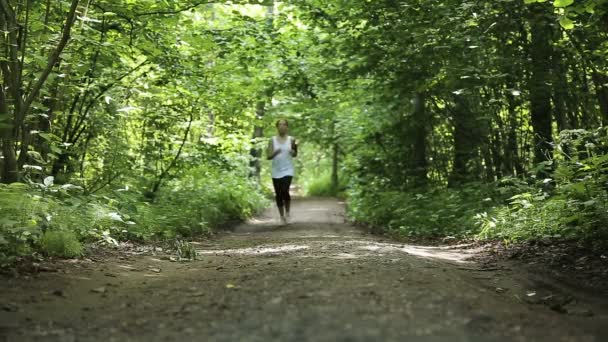 Menina corre na estrada em um campo . — Vídeo de Stock