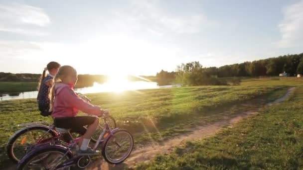 Niñas montando bicicleta en el campo — Vídeo de stock
